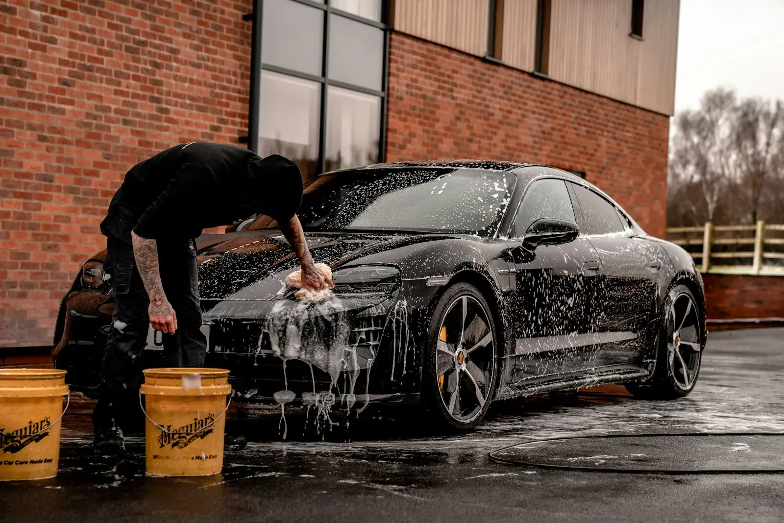 Hand wash and foam on a black sedan before handover